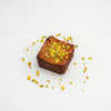 Square piece of Brownie with yellow toppings on a white background

