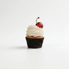 Cupcake with white frosting and a cherry on top against a white background in morristown nj