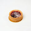 Plum Tartlet Small round tart with a purple filling on a white background