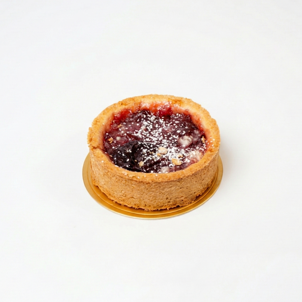 Plum Tartlet Small round tart with a purple filling on a white background